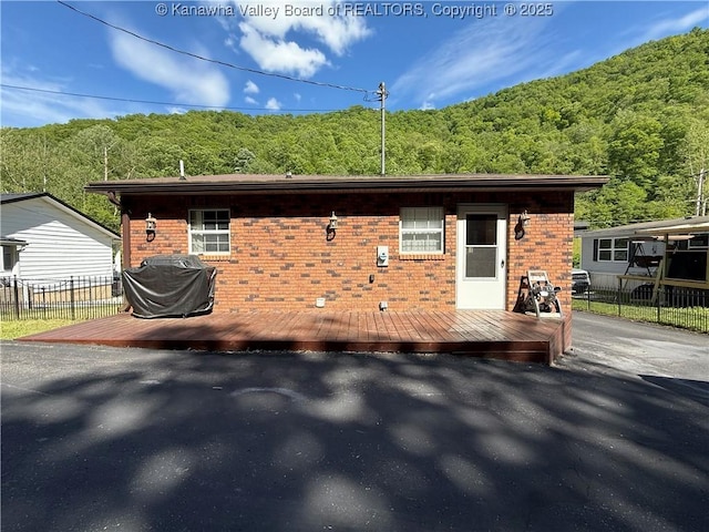 1886 Whitman Creek Rd, Whitman, WV 25652 - view of front of home featuring a view of trees, fence, brick siding, and a deck