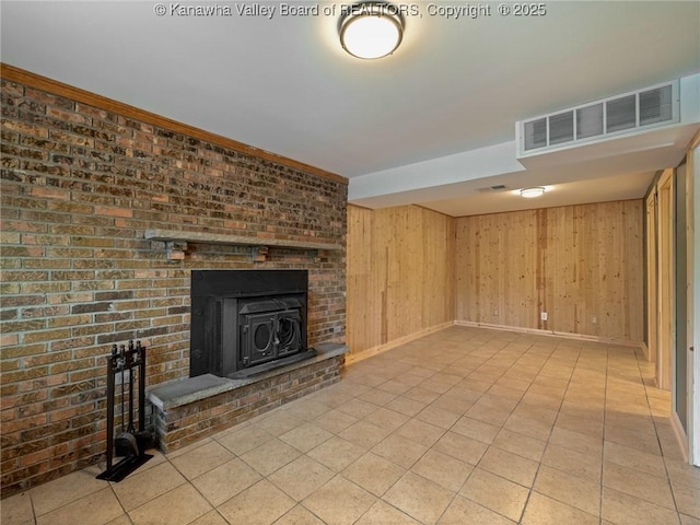 unfurnished living room featuring baseboards, light tile patterned floors, and wood walls