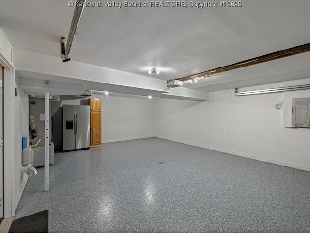 finished below grade area featuring stainless steel refrigerator with ice dispenser, baseboards, and heating unit