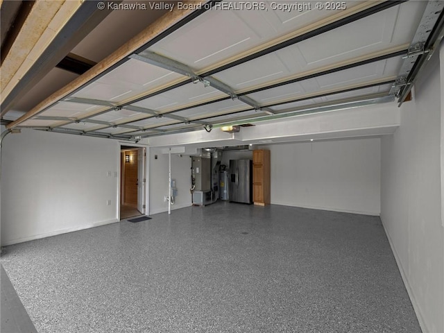garage featuring heating unit, stainless steel fridge with ice dispenser, a garage door opener, baseboards, and water heater