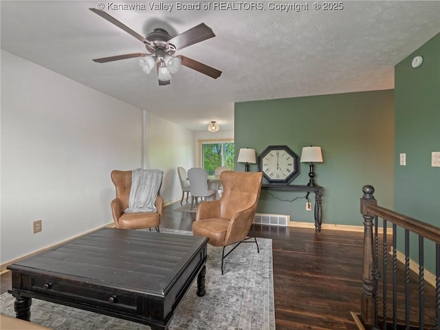 sitting room featuring wood finished floors, a ceiling fan, baseboards, and an upstairs landing