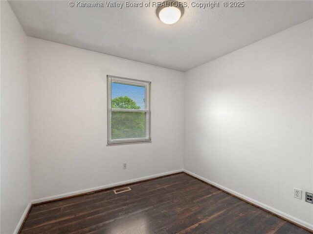 empty room with baseboards and dark wood-style floors
