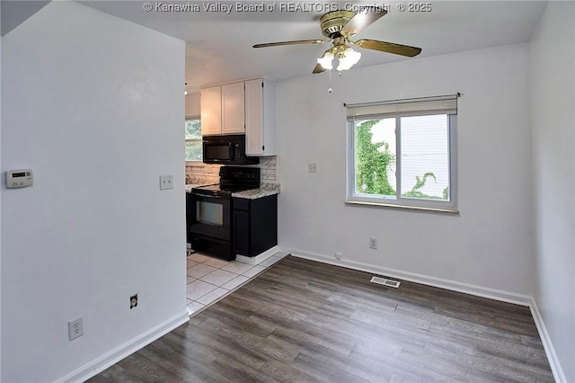 4707 A Marklana Ln, South Charleston, WV 25309 - kitchen featuring black appliances, healthy amount of natural light, white cabinets, and decorative backsplash