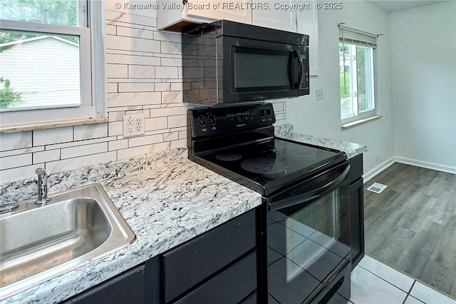 4707 A Marklana Ln, South Charleston, WV 25309 - kitchen featuring black appliances, a sink, decorative backsplash, baseboards, and light stone counters
