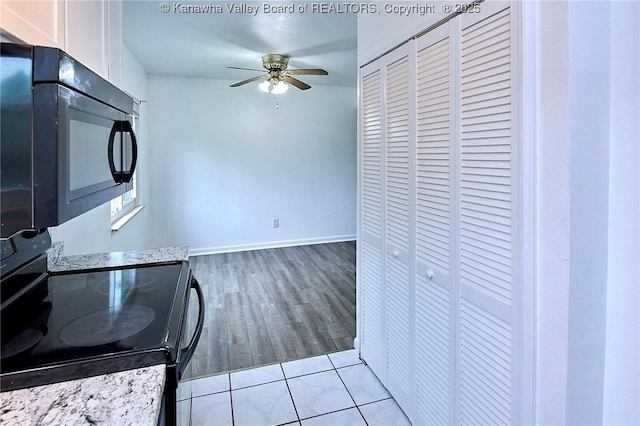 4707 A Marklana Ln, South Charleston, WV 25309 - kitchen with black appliances, a ceiling fan, white cabinets, light wood-style floors, and baseboards
