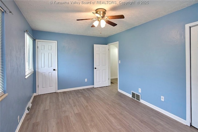 4707 A Marklana Ln, South Charleston, WV 25309 - unfurnished bedroom featuring wood finished floors, a textured ceiling, baseboards, and a ceiling fan