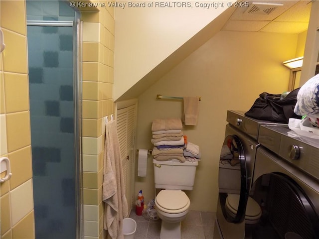 101 Ebony Dr, Cross Lanes, WV 25313 - bathroom featuring separate washer and dryer, toilet, a stall shower, and tile patterned flooring