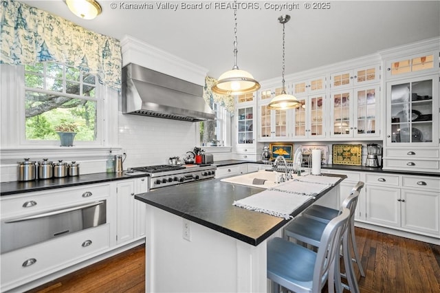 1223 Staunton Rd, Charleston, WV 25314 - kitchen featuring wall chimney range hood, a warming drawer, dark countertops, a sink, and an island with sink