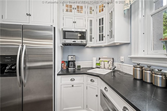 1223 Staunton Rd, Charleston, WV 25314 - kitchen featuring stainless steel appliances, a sink, white cabinetry, dark countertops, and glass insert cabinets