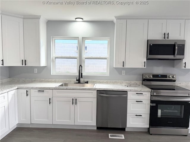 202 Josephine Ave, Madison, WV 25130 - kitchen with stainless steel appliances, a sink, white cabinetry, and wood finished floors
