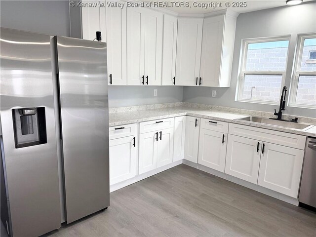 202 Josephine Ave, Madison, WV 25130 - kitchen with appliances with stainless steel finishes, a sink, light wood-style flooring, and white cabinets