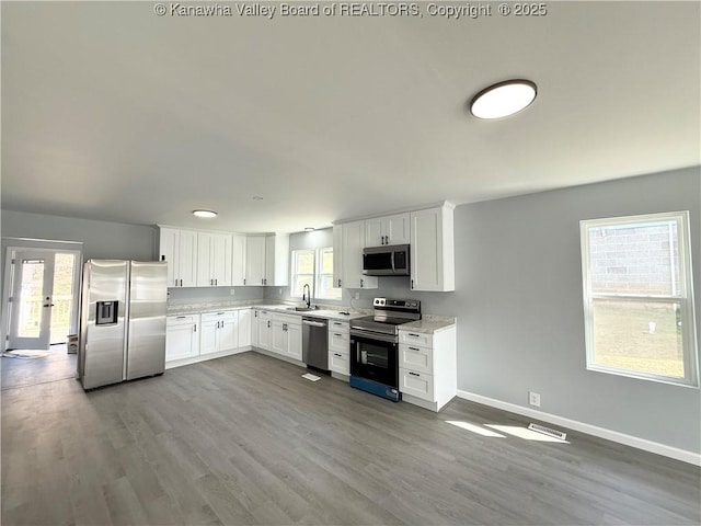 202 Josephine Ave, Madison, WV 25130 - kitchen with stainless steel appliances, a sink, light countertops, baseboards, and dark wood finished floors
