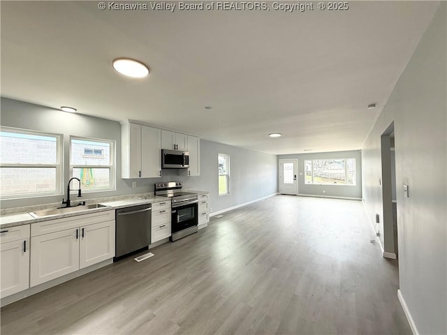 202 Josephine Ave, Madison, WV 25130 - kitchen with appliances with stainless steel finishes, a sink, light countertops, baseboards, and light wood-style flooring