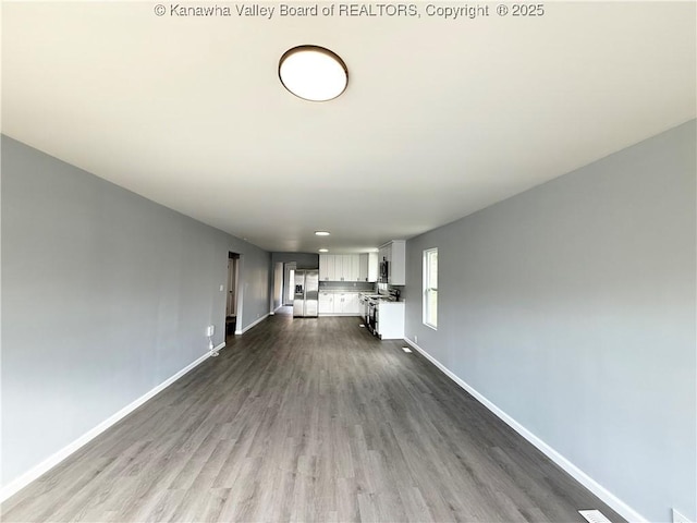 202 Josephine Ave, Madison, WV 25130 - unfurnished living room with baseboards and dark wood-style floors
