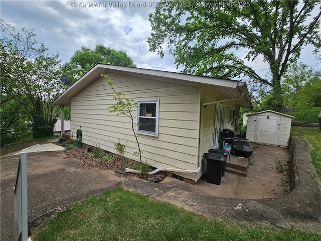 1000 Park Dr, Dunbar, WV 25064 - view of side of home featuring a shed, an outdoor structure, and a patio