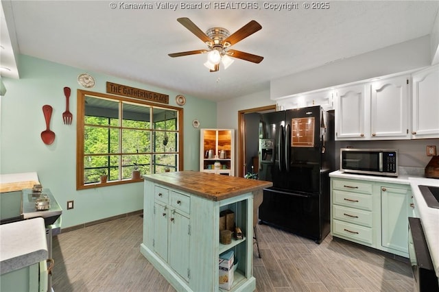 3589 Mount Union Rd, Fraziers Bottom, WV 25082 - kitchen with black fridge with ice dispenser, stainless steel microwave, wooden counters, green cabinetry, and light wood-style floors
