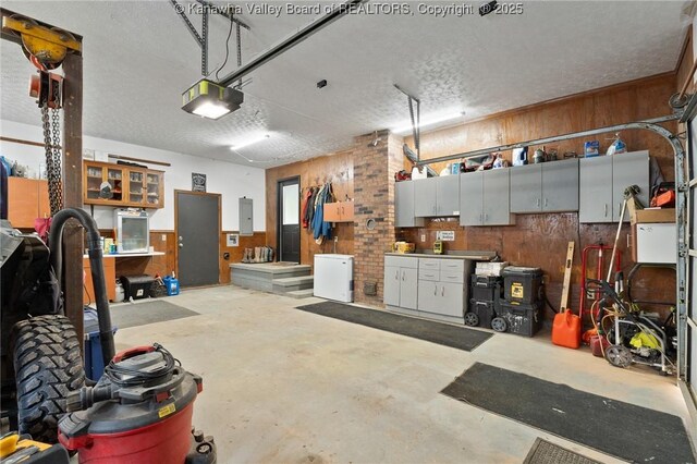 3589 Mount Union Rd, Fraziers Bottom, WV 25082 - garage featuring electric panel, wood walls, and a garage door opener