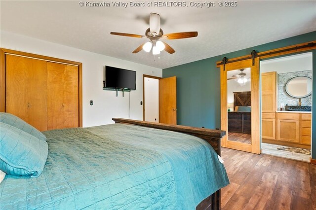 3589 Mount Union Rd, Fraziers Bottom, WV 25082 - bedroom featuring wood finished floors, a closet, ensuite bath, a ceiling fan, and a barn door