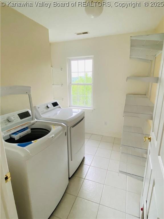 516 Woodbridge Dr, Charleston, WV 25311 - washroom with washing machine and clothes dryer, light tile patterned flooring, and baseboards
