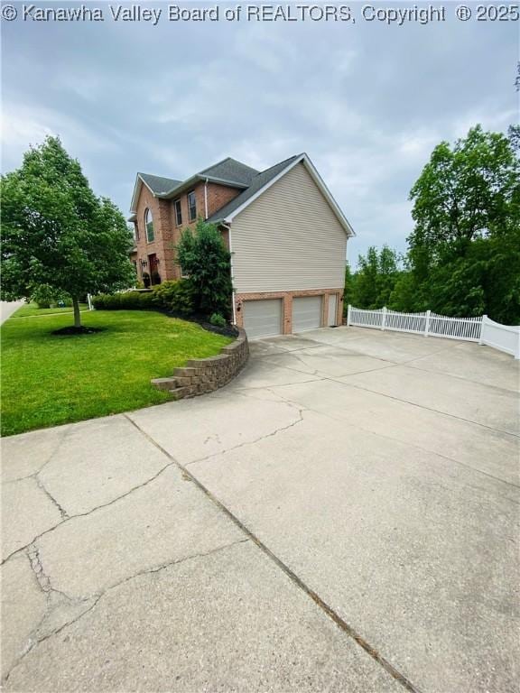516 Woodbridge Dr, Charleston, WV 25311 - view of side of home with brick siding, a garage, and driveway