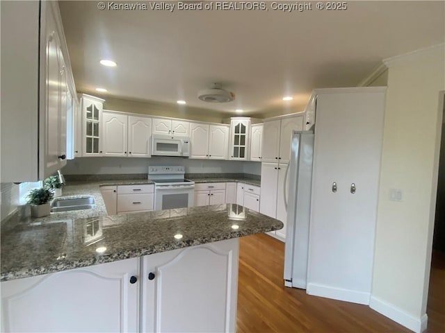 516 Woodbridge Dr, Charleston, WV 25311 - kitchen with white appliances, a peninsula, dark wood-type flooring, glass insert cabinets, and baseboards
