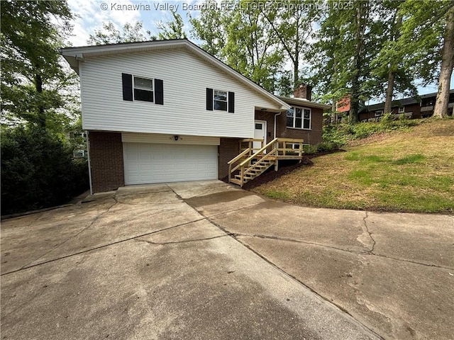 2 Stephanie Ln, Saint Albans, WV 25177 - view of front of property with driveway, brick siding, an attached garage, and a chimney