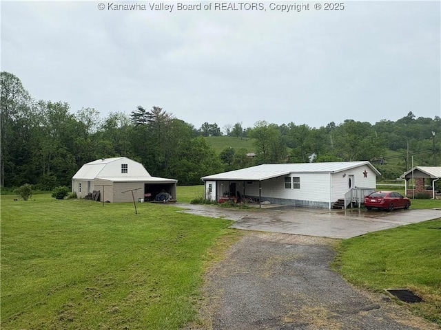 3888-3890 Charleston Rd, Gandeeville, WV 25243 - view of green lawn with asphalt driveway, a carport, and an outdoor structure