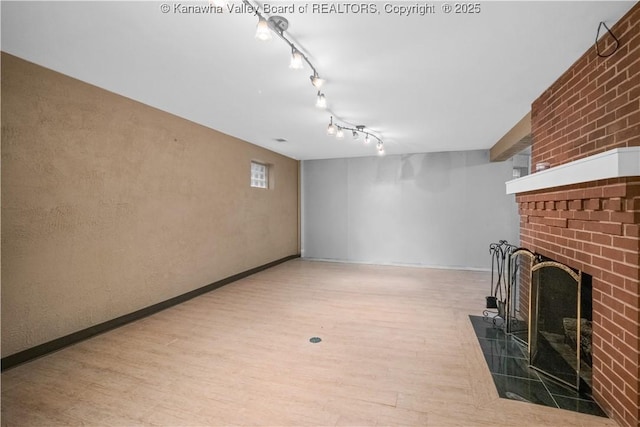 102 49th St SE, Charleston, WV 25304 - basement featuring a brick fireplace, wood finished floors, rail lighting, and baseboards