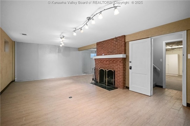 102 49th St SE, Charleston, WV 25304 - unfurnished living room with light wood-style flooring, a brick fireplace, and stairs