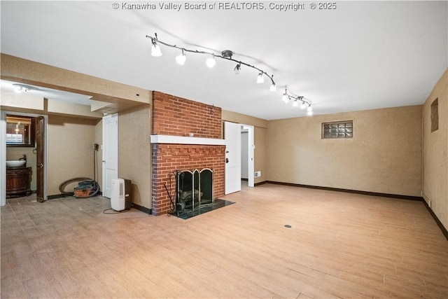 102 49th St SE, Charleston, WV 25304 - unfurnished living room featuring light wood finished floors, a brick fireplace, and baseboards