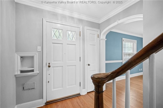 102 49th St SE, Charleston, WV 25304 - entryway featuring wood finished floors, crown molding, arched walkways, baseboards, and stairway