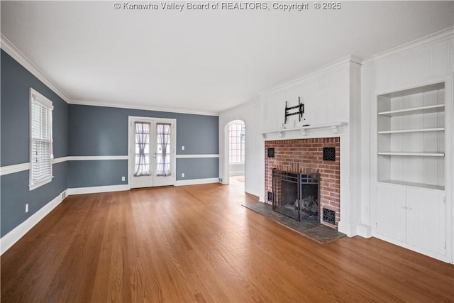 102 49th St SE, Charleston, WV 25304 - unfurnished living room featuring a fireplace, crown molding, built in features, baseboards, and wood finished floors