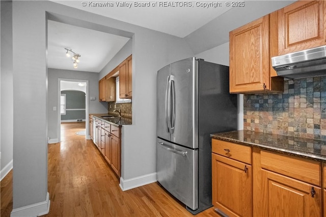 102 49th St SE, Charleston, WV 25304 - kitchen with freestanding refrigerator, arched walkways, light wood-style floors, tasteful backsplash, and baseboards