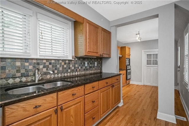 102 49th St SE, Charleston, WV 25304 - kitchen featuring a sink, backsplash, light wood-type flooring, and dark stone countertops