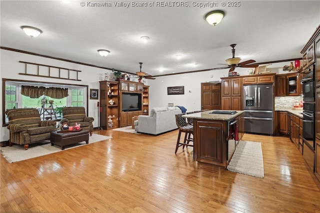 3282 Greenview Rd, South Charleston, WV 25303 - kitchen featuring stainless steel fridge with ice dispenser, a ceiling fan, open floor plan, black oven, and crown molding