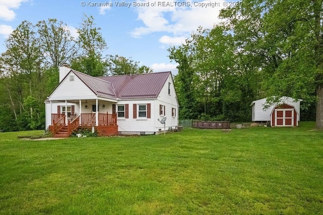 view of front of home with a storage shed, a chimney, a front yard, and an outdoor structure
