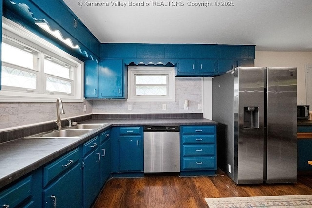 kitchen featuring stainless steel appliances, blue cabinets, a sink, and healthy amount of natural light