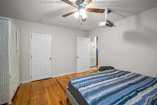 bedroom featuring wood-type flooring, baseboards, and a ceiling fan