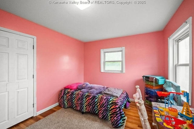 bedroom featuring wood finished floors and baseboards