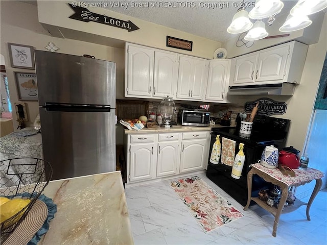 103 Chestnut Dr, Peytona, WV 25154 - kitchen with appliances with stainless steel finishes, light marble finish flooring, under cabinet range hood, white cabinets, and a textured ceiling