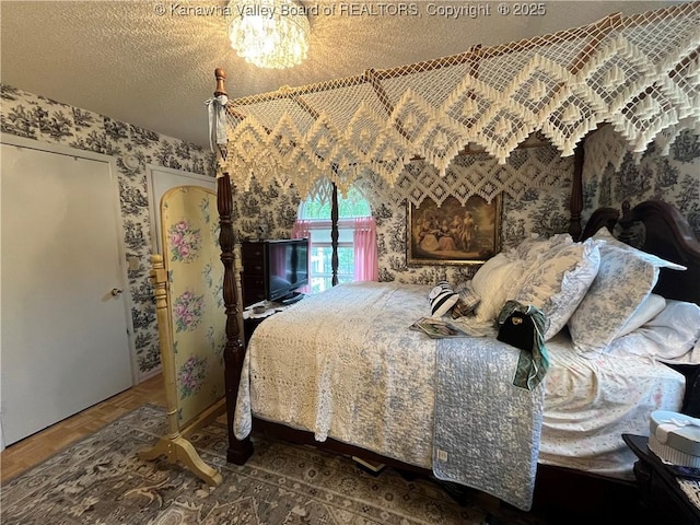 103 Chestnut Dr, Peytona, WV 25154 - bedroom with wallpapered walls, a textured ceiling, and a chandelier