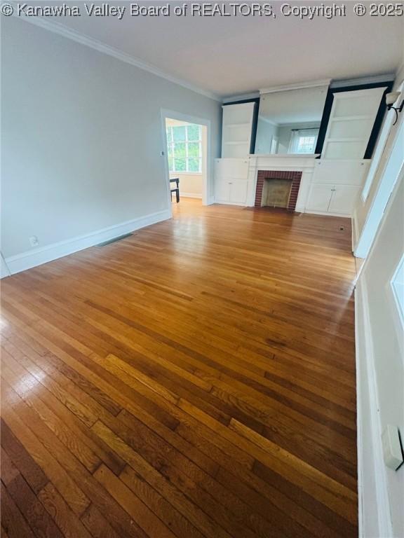 930 Mathews Ave, Charleston, WV 25302 - unfurnished living room featuring hardwood / wood-style flooring, ornamental molding, a fireplace, and baseboards