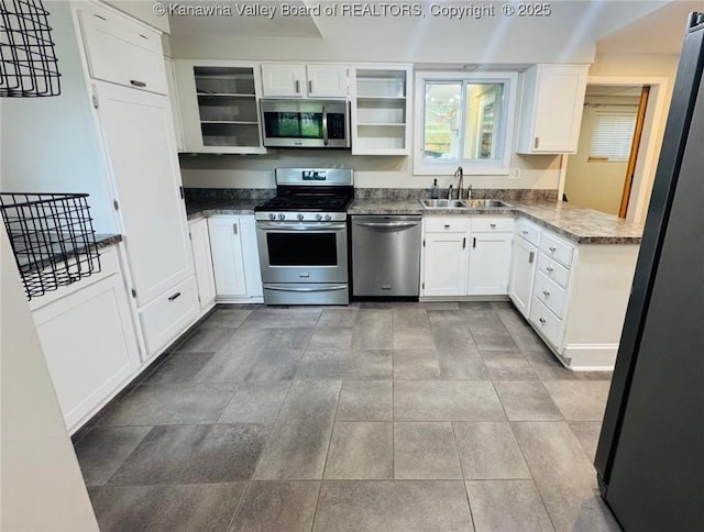 930 Mathews Ave, Charleston, WV 25302 - kitchen with stainless steel appliances, a sink, open shelves, white cabinets, and dark stone counters