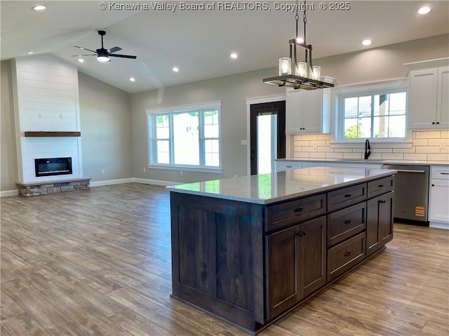 41 Day Star Dr, Evans, WV 25241 - kitchen with stainless steel dishwasher, a sink, wood finished floors, white cabinetry, and vaulted ceiling