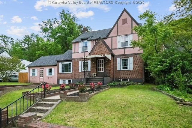 608 Kanawha Ave, Clendenin, WV 25045 - rear view of house with stucco siding, a lawn, roof with shingles, brick siding, and a chimney