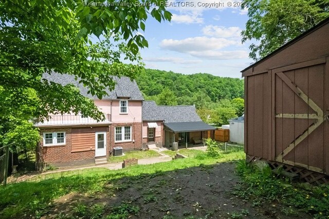 608 Kanawha Ave, Clendenin, WV 25045 - back of property with a storage shed, brick siding, fence, central AC, and an outbuilding
