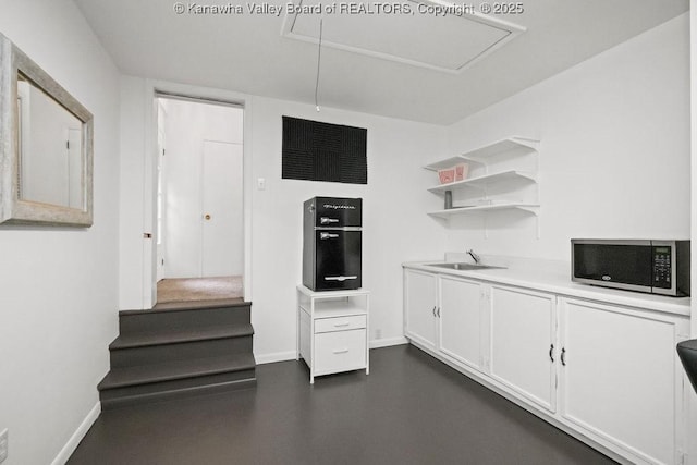 608 Kanawha Ave, Clendenin, WV 25045 - kitchen with stainless steel microwave, a sink, white cabinets, light countertops, and open shelves