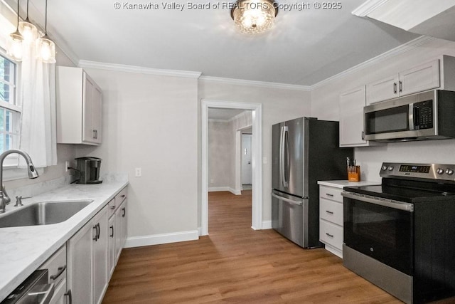 608 Kanawha Ave, Clendenin, WV 25045 - kitchen featuring appliances with stainless steel finishes, a sink, crown molding, light countertops, and light wood finished floors