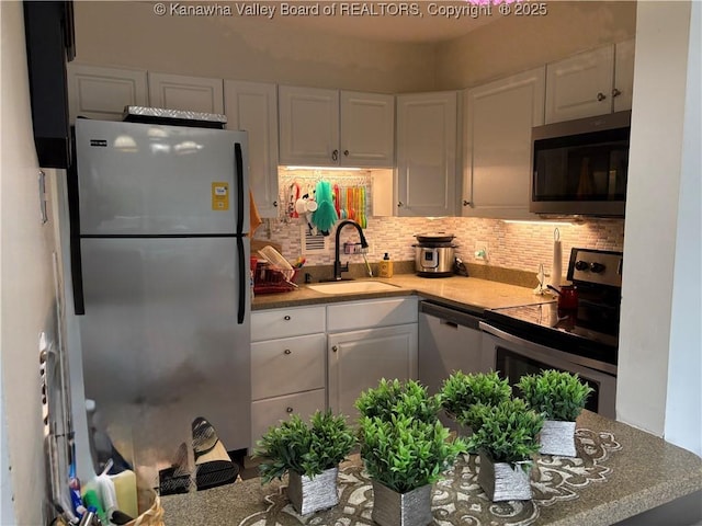 1800 Roundhill Rd Unit 901, Charleston, WV 25304 - kitchen featuring stainless steel appliances, a sink, white cabinets, and decorative backsplash