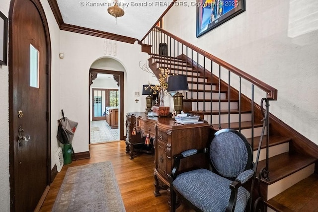 606 Fort Hill Dr, Charleston, WV 25314 - stairs featuring wood finished floors, arched walkways, crown molding, and baseboards